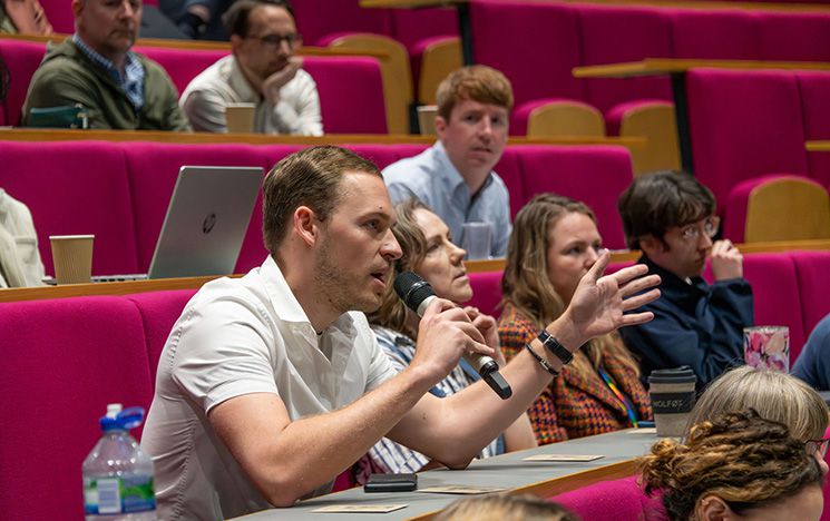 Jubilee lecture theatre with attendee speaking into a microphone