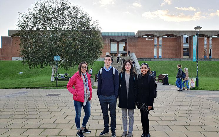 Aigerim Mussabalinova and three friends stand in Library Square with the Library behind them